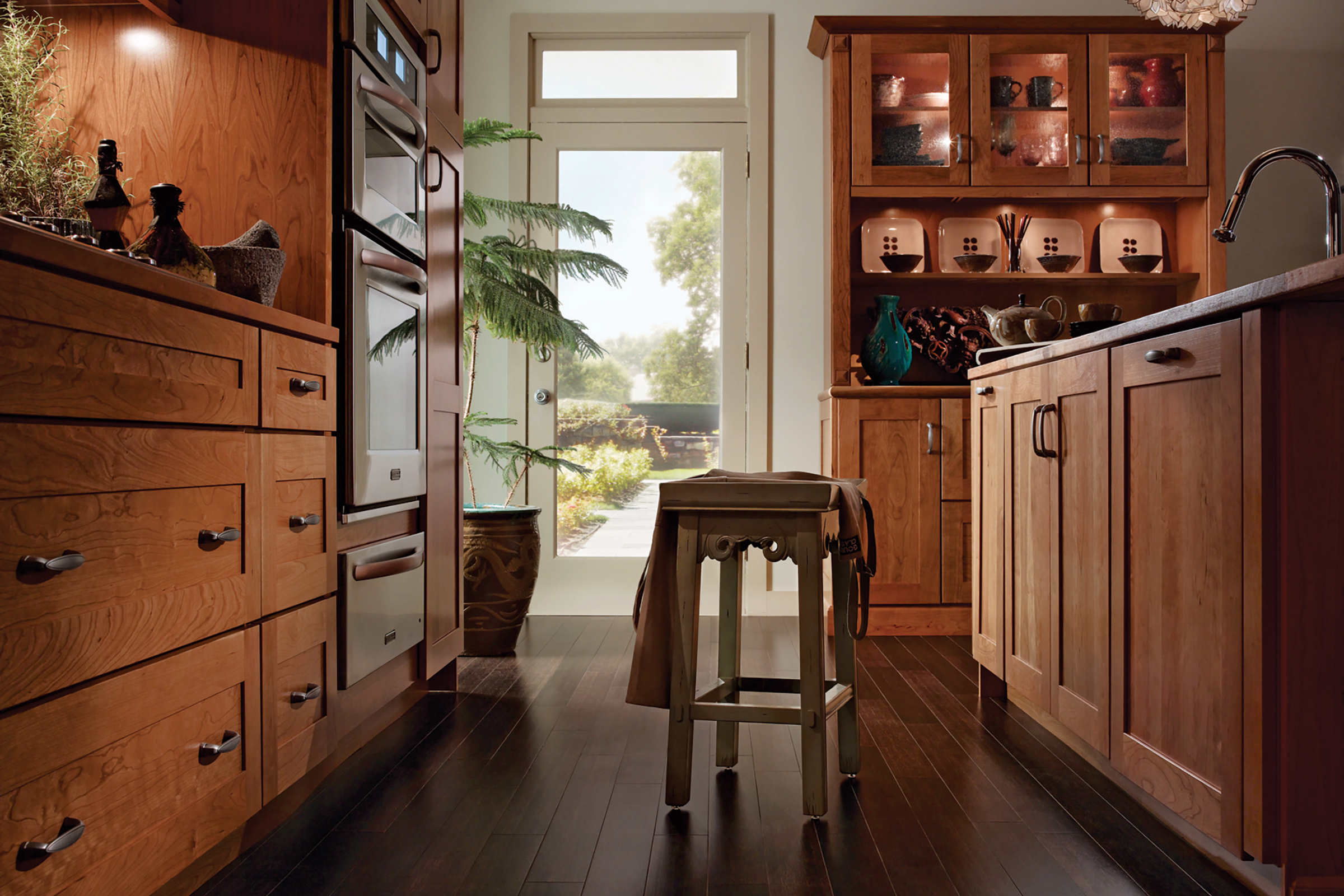 Inviting transitional-style kitchen with KraftMaid Honey Spice stain color Shaker-style doors in open floor plan