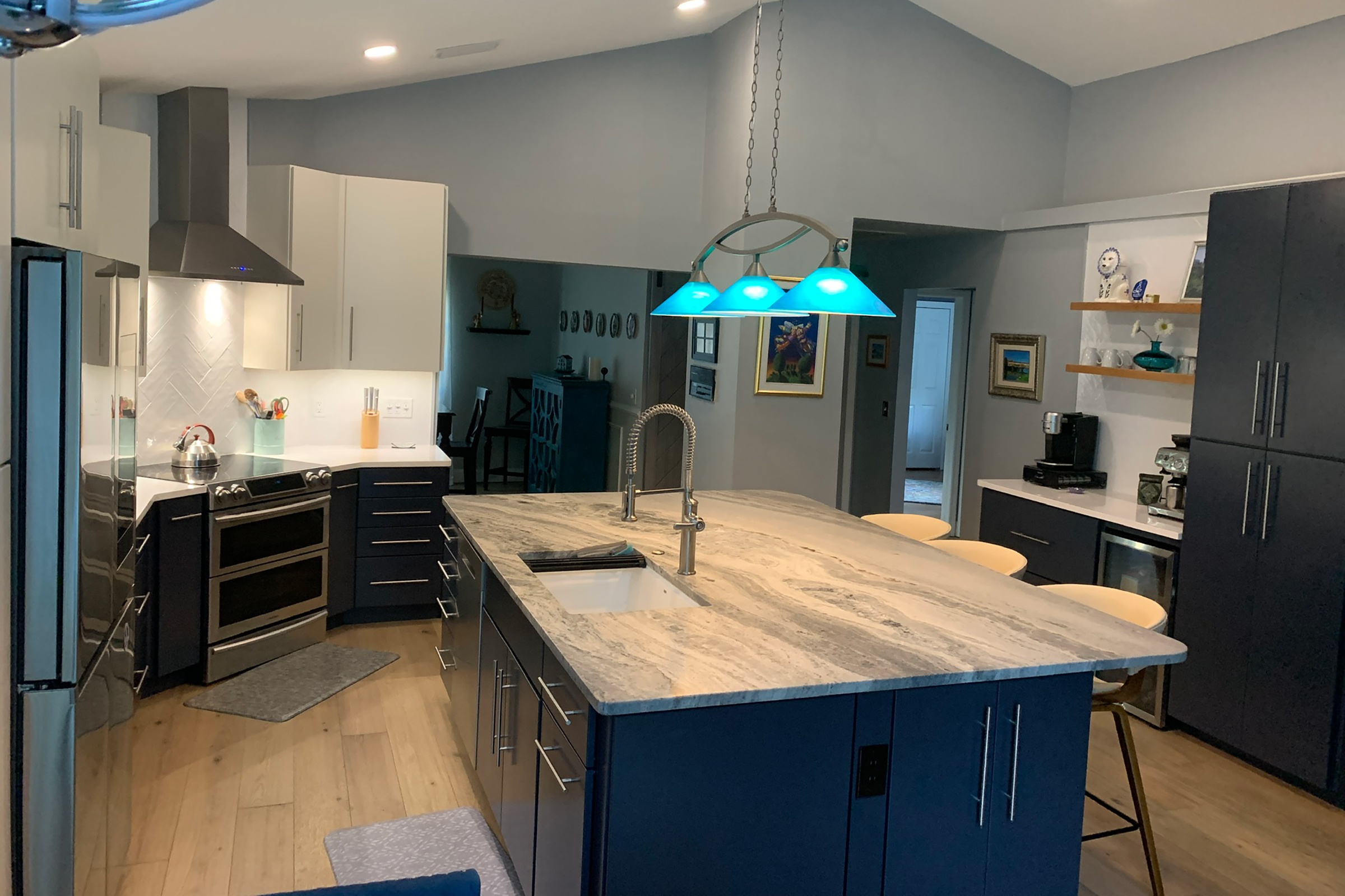 Modern-style kitchen with sloped ceiling, angled layout, and large center island in KraftMaid slab door cabinets.