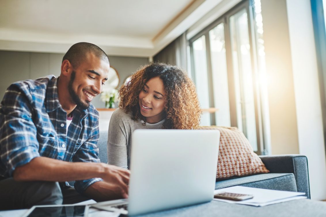 Couple using laptop to explore KraftMaid kitchen remodel estimate tools