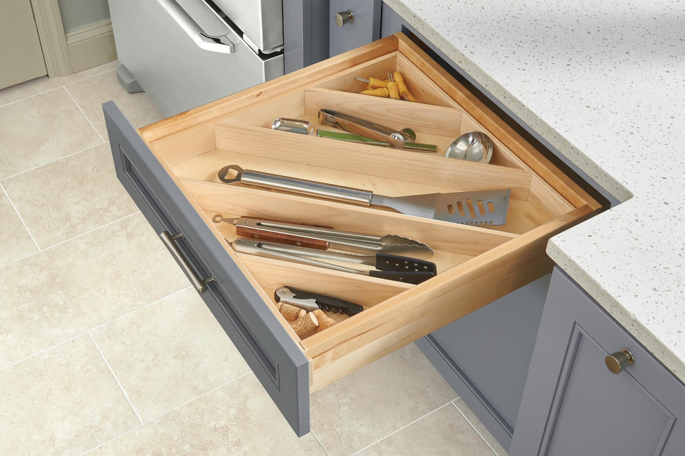 Various kitchen utensils neatly organized in a drawer with angled dividers