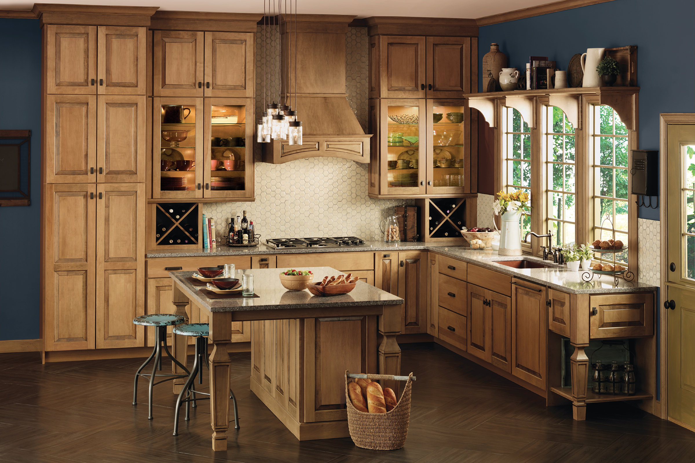 Kitchen island with furniture legs and raised Husk stain panel doors in Gothic-inspired KraftMaid L-shape kitchen