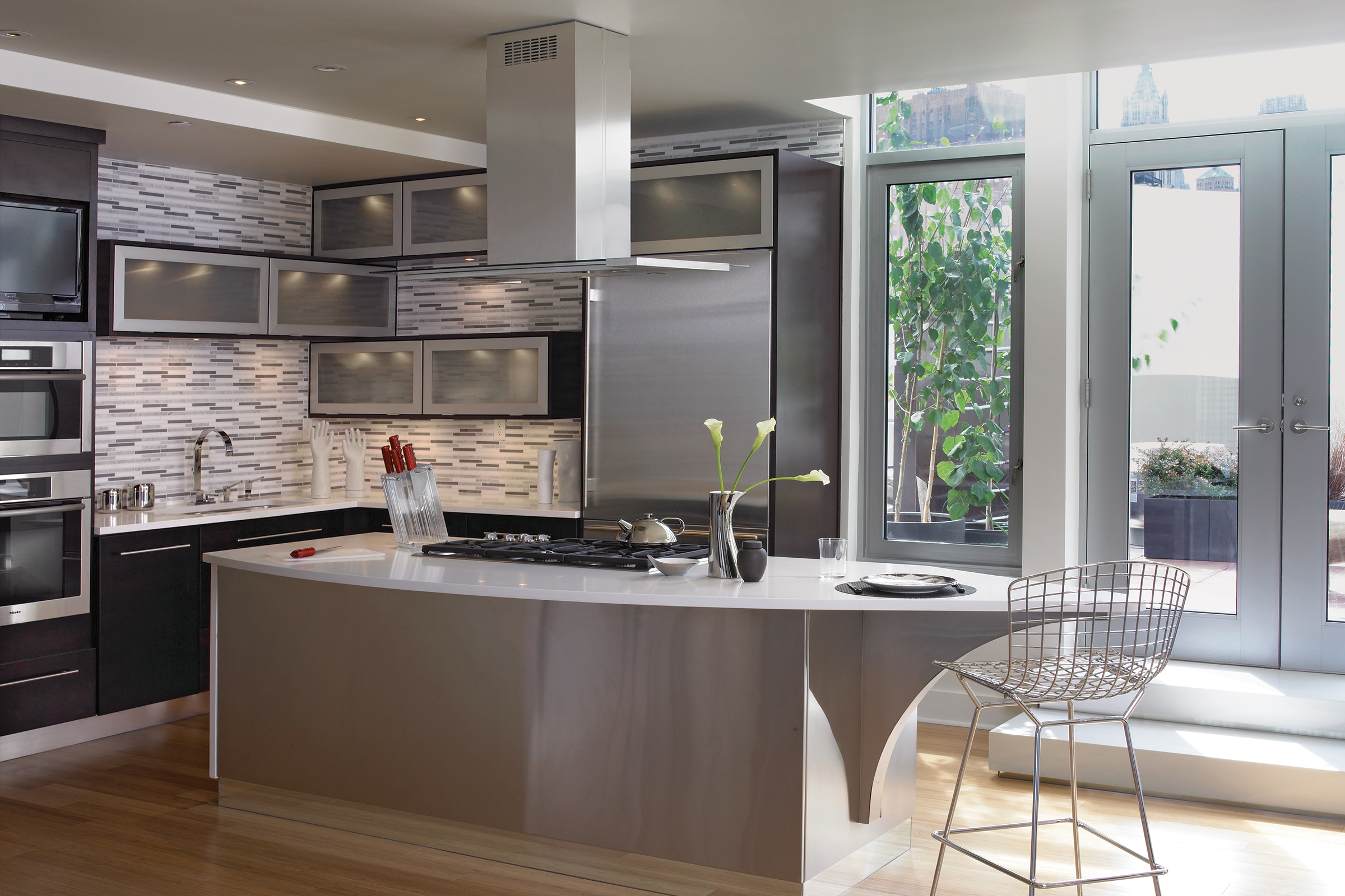 Stainless steel-clad kitchen island in a Modern KraftMaid kitchen