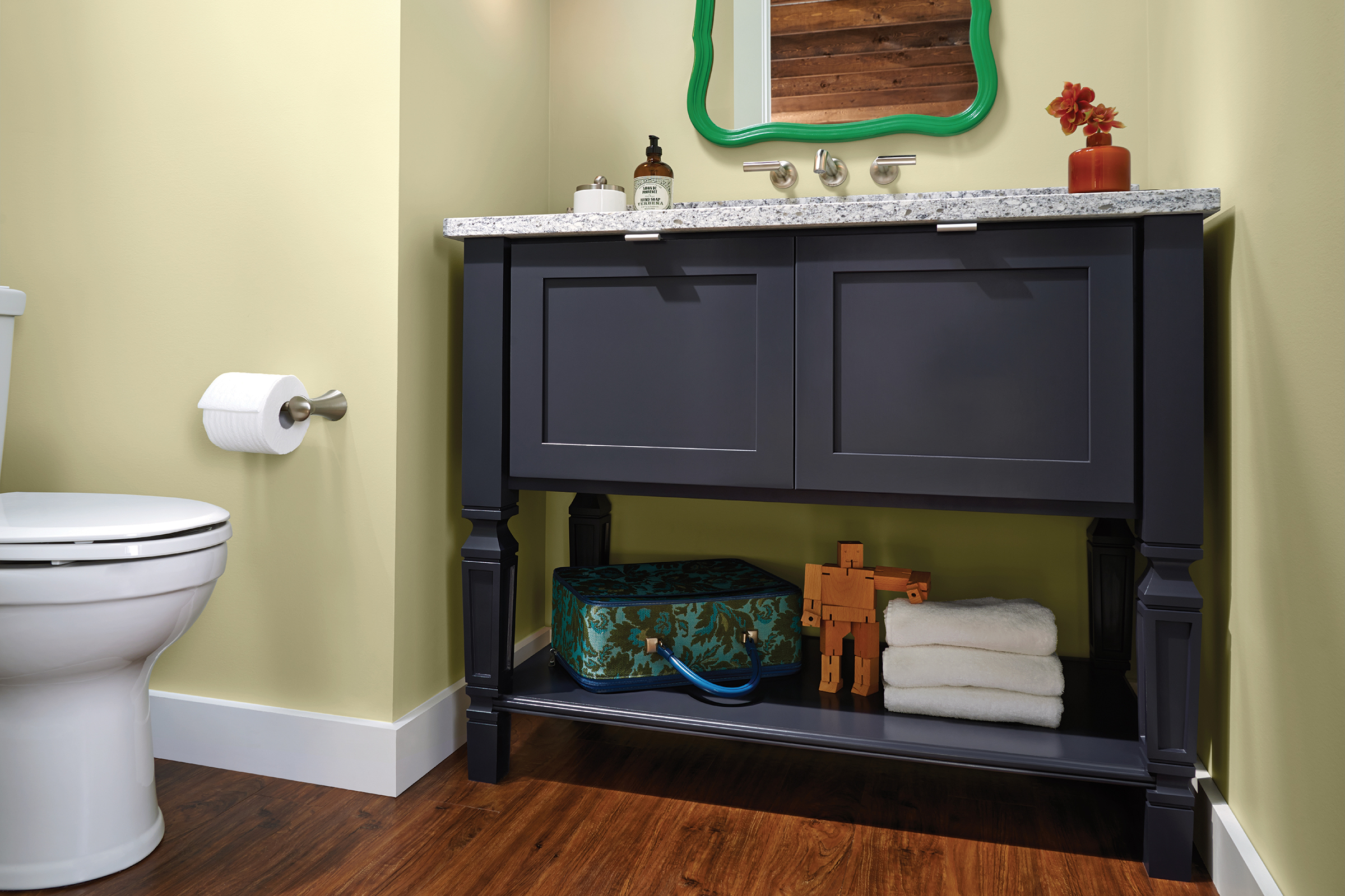 KraftMaid bathroom vanity sink cabinet with lower storage shelf and carved legs in Midnight painted finish 