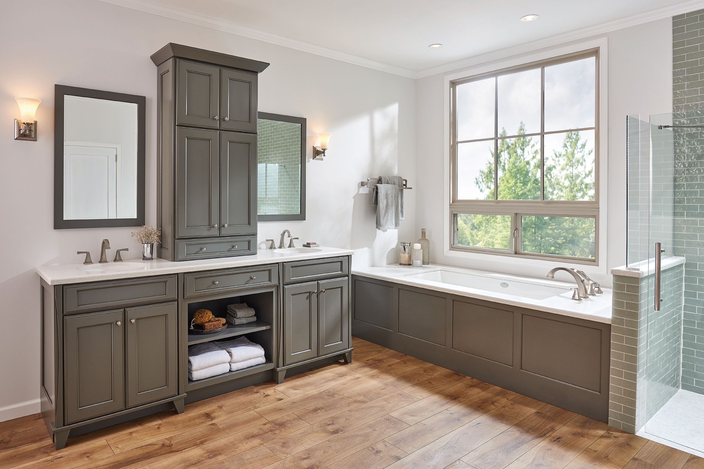 Airy bathroom with Roman tub, separate shower and KraftMaid double bathroom vanity with tall cabinet in Greyloft painted finish