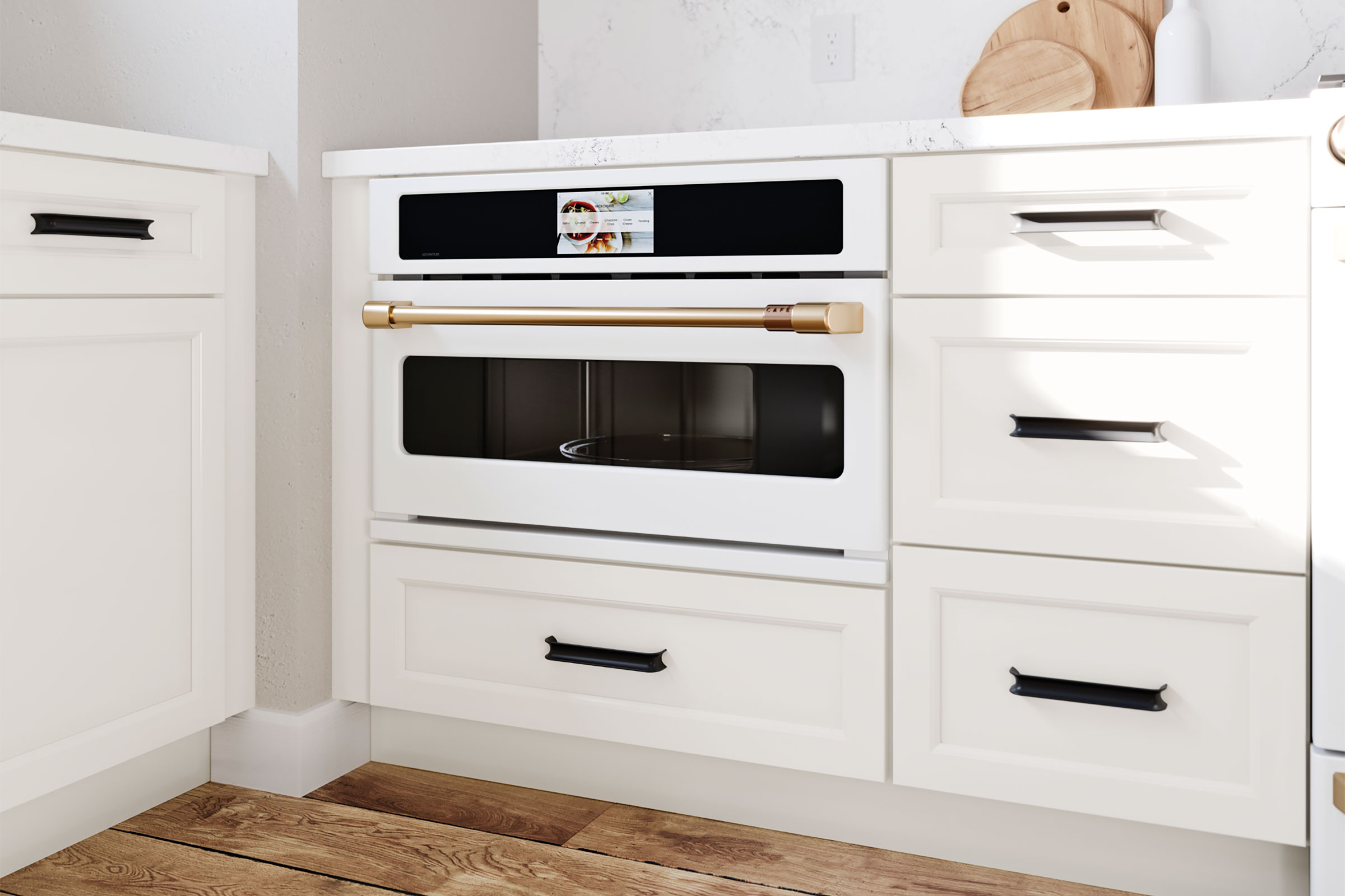 White under-counter oven in KraftMaid base appliance cabinet with Frost White painted doors and black hardware handles 