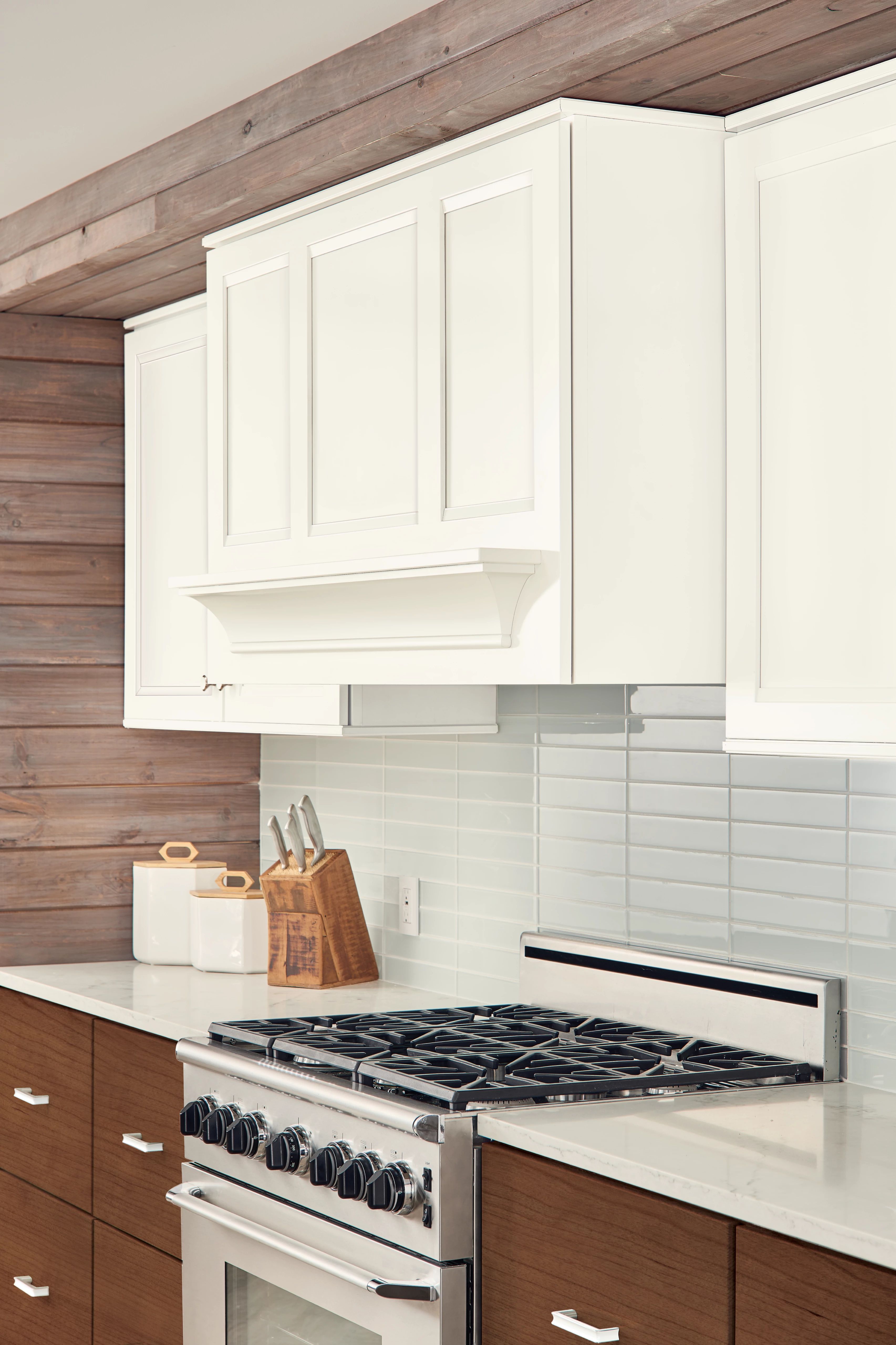 KraftMaid range hood finished in Dove White to match wall cabinets in a contemporary kitchen