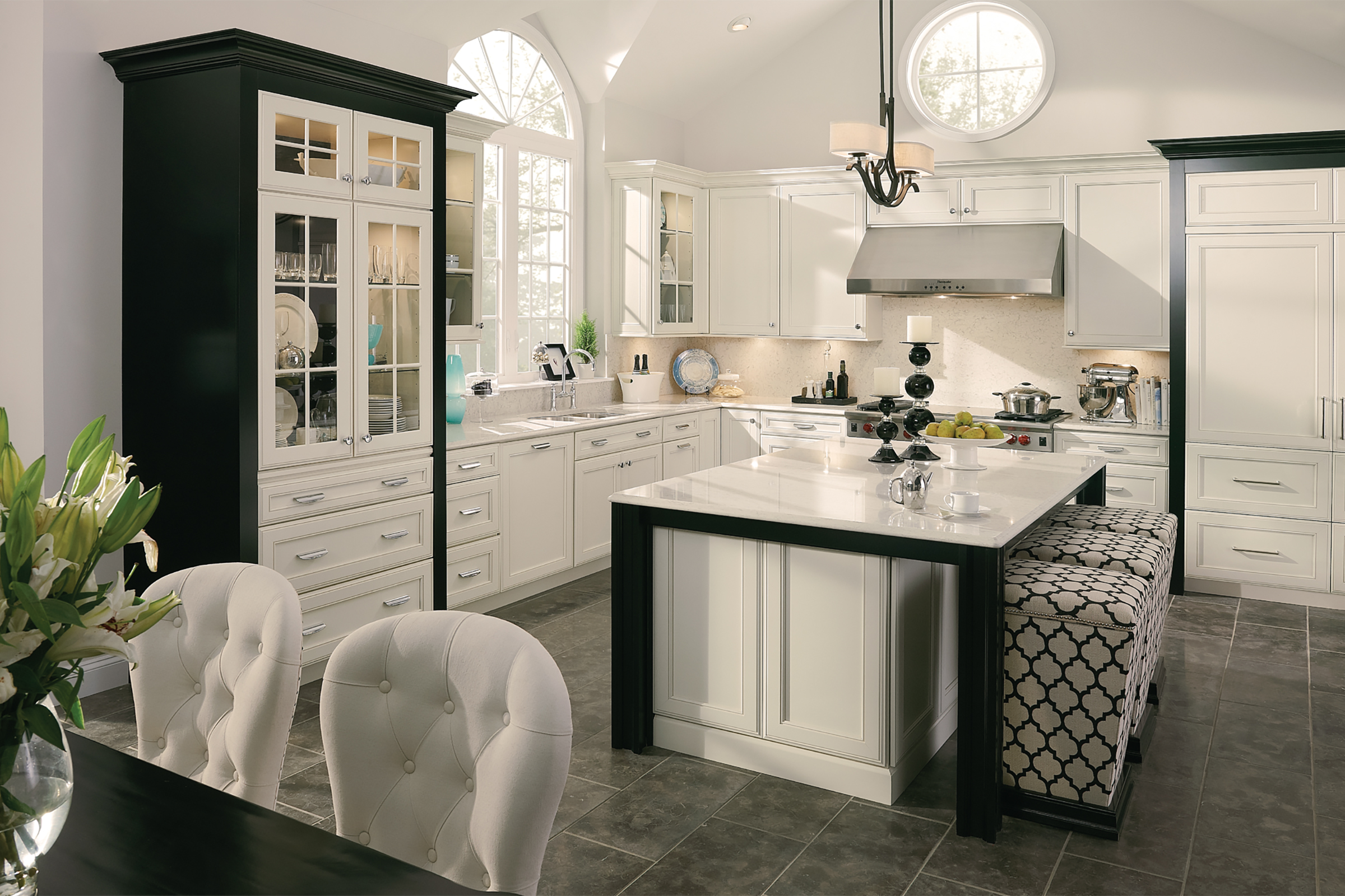 KraftMaid cabinetry in off-white Canvas paint punctuated with black Onyx accents in a glam two-tone tuxedo kitchen design