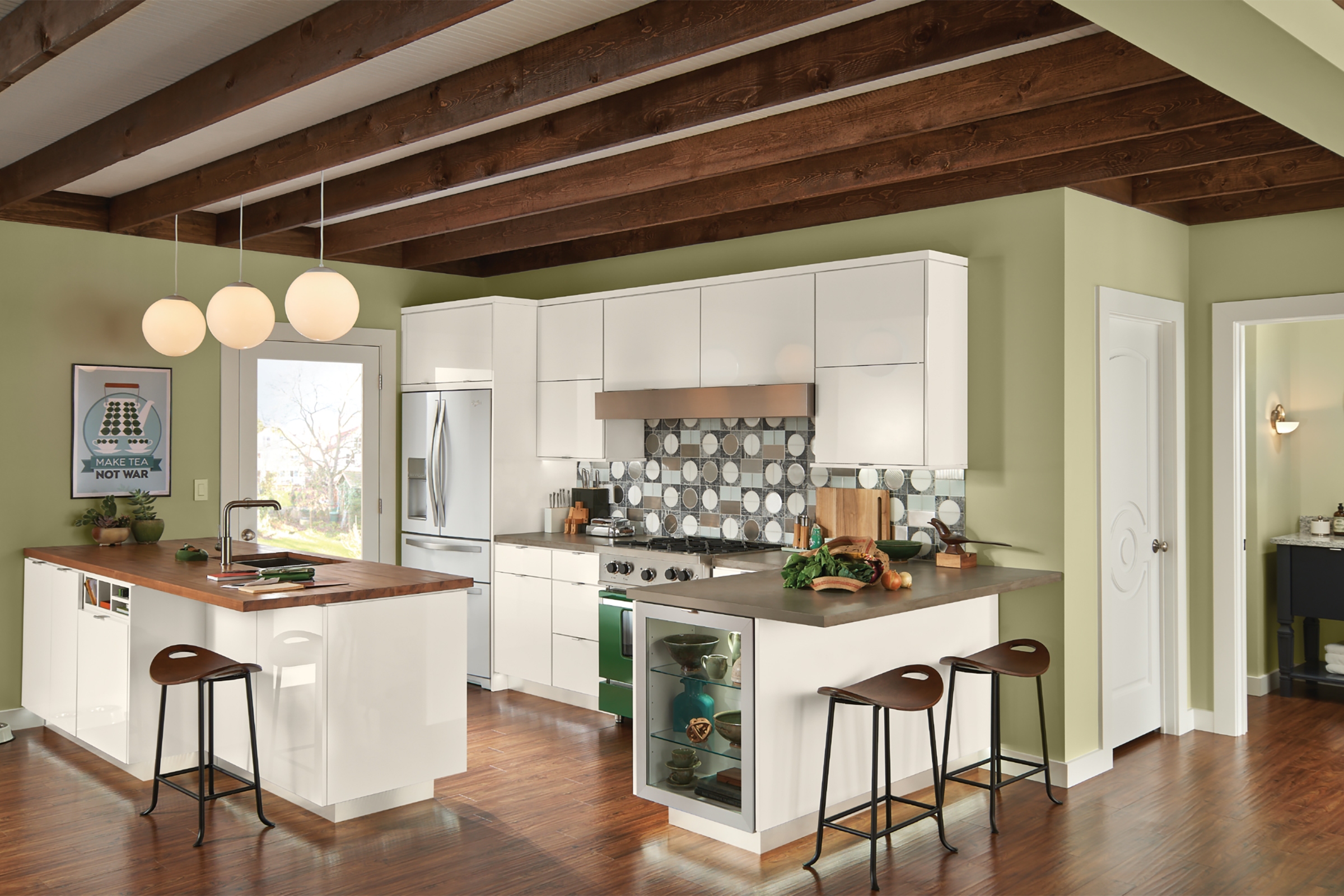 KraftMaid pistachio green kitchen accent wall with white cabinets and dark countertops