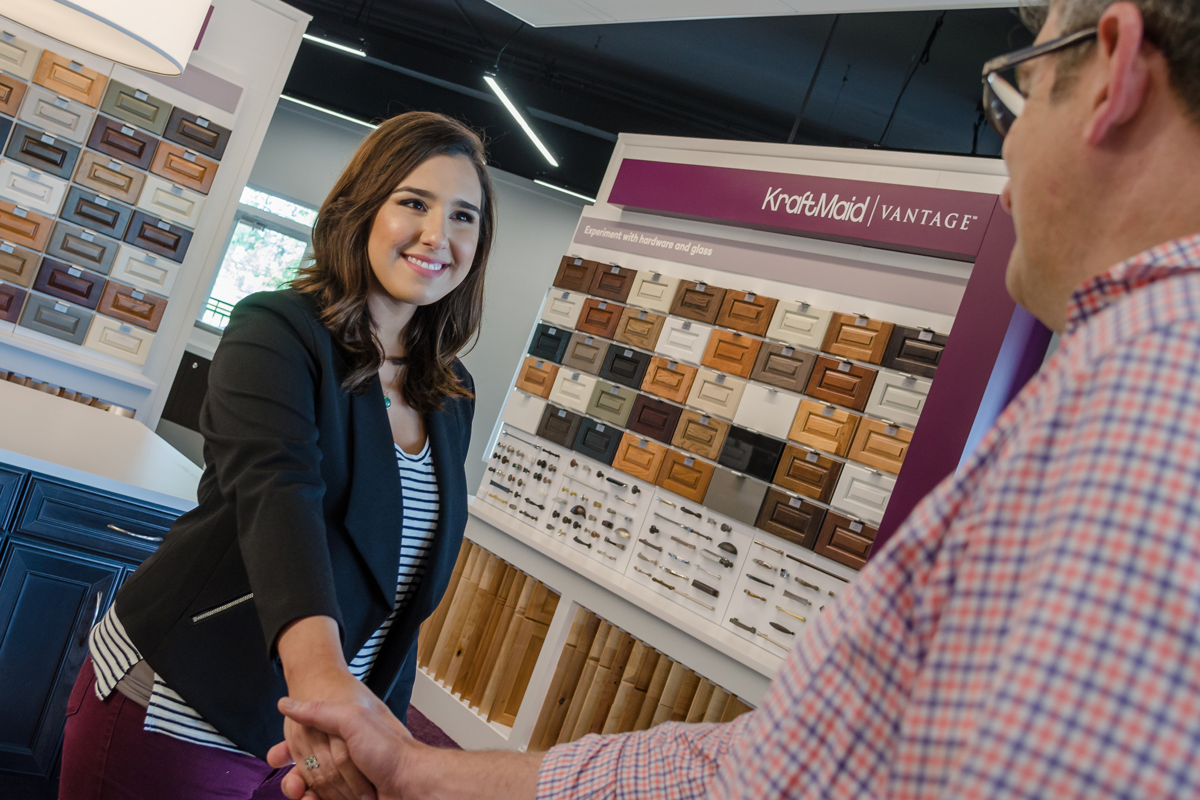 Kitchen designer greeting customer in KraftMaid cabinet showroom